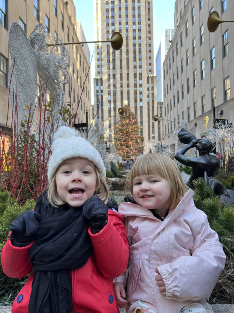 The Singing Suitcase owner Melissa's daughters on vacation at the Rockefeller Center Christmas tree