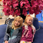 The Singing Suitcase owner Melissa's daughters sitting in a hotel lobby